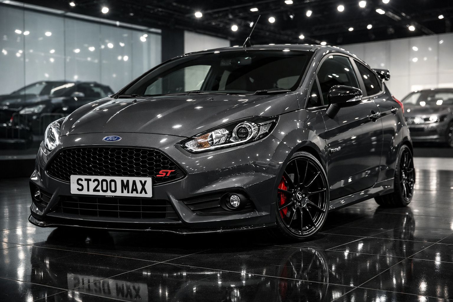 Ford Focus ST cinzento metálico estacionado em interior com jantes pretas desportivas e travões vermelhos.