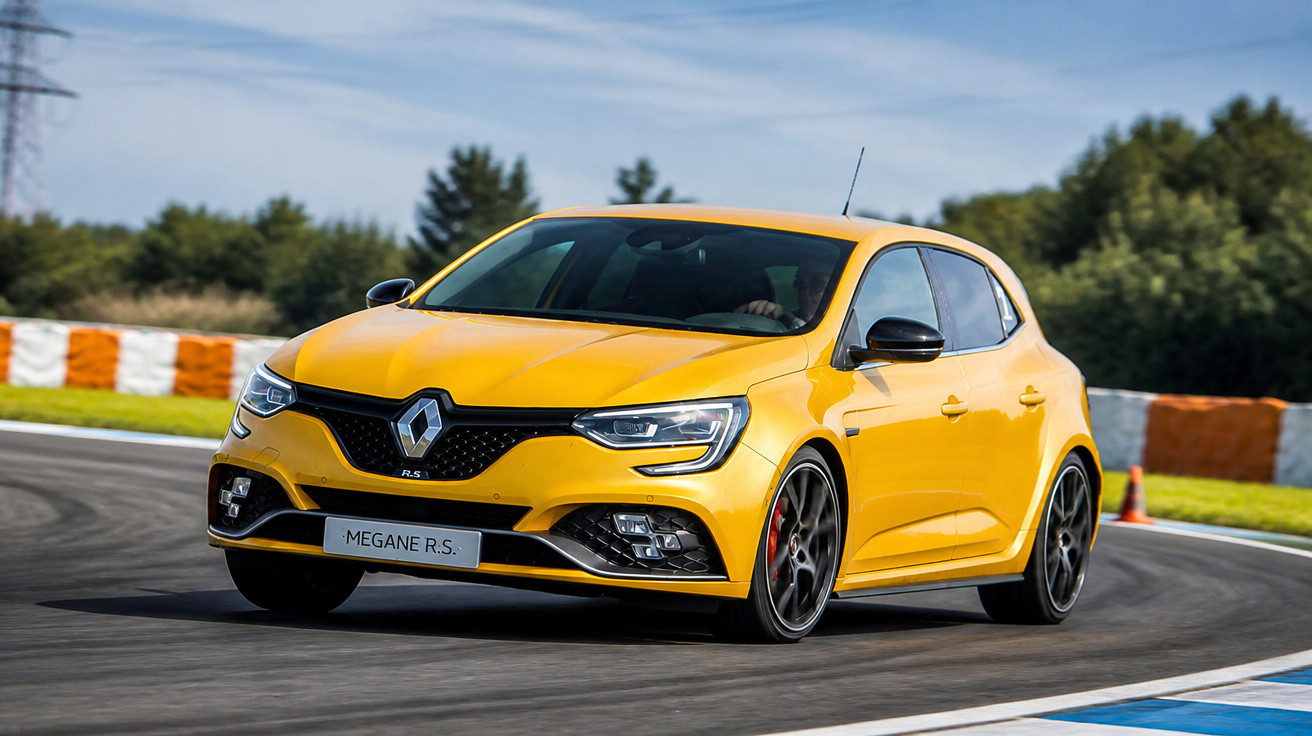 Renault Megane R.S. amarelo em curva numa pista de corrida com fundo de árvores e céu azul.