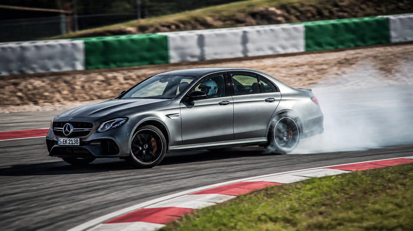 Carro desportivo Mercedes-Benz prata em derrapagem numa curva de circuito automóvel.
